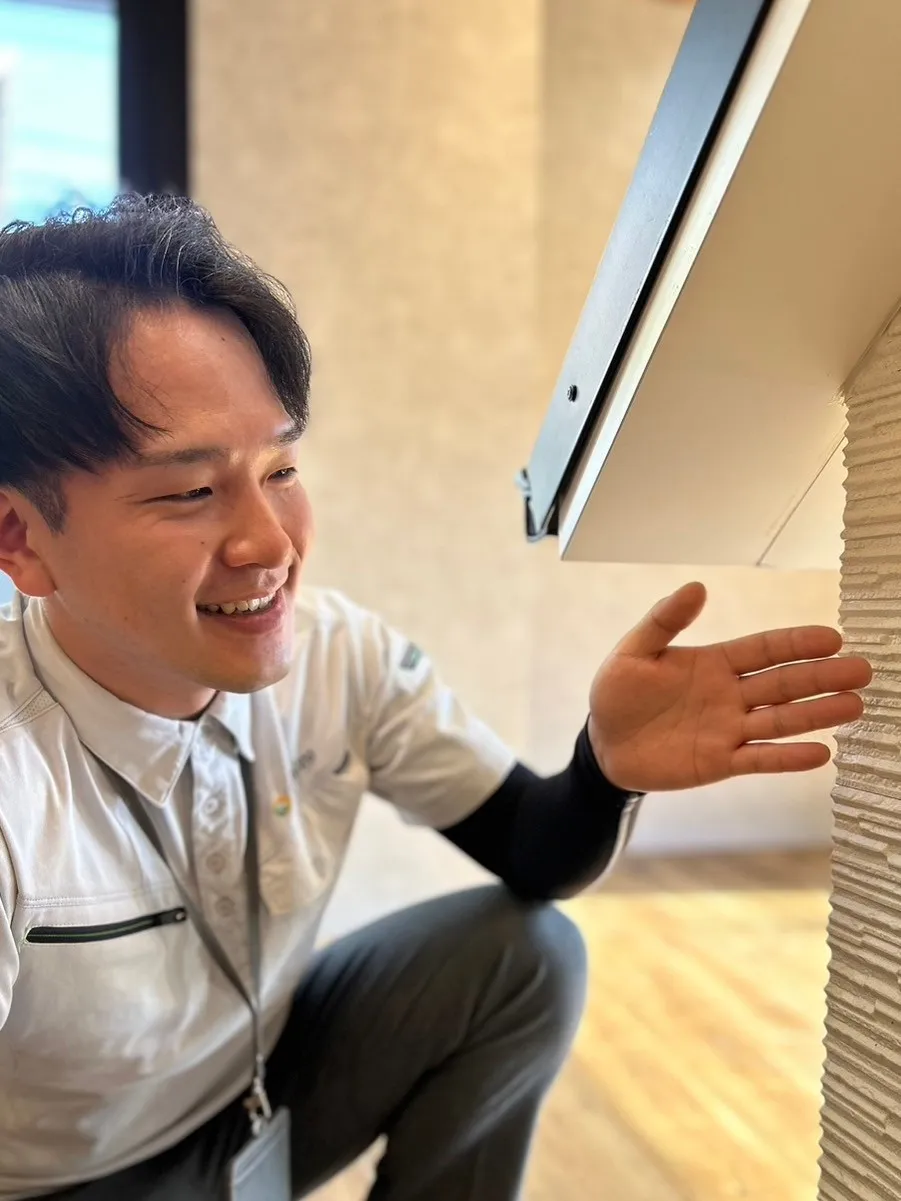 外壁について笑顔で説明するスタッフの野田