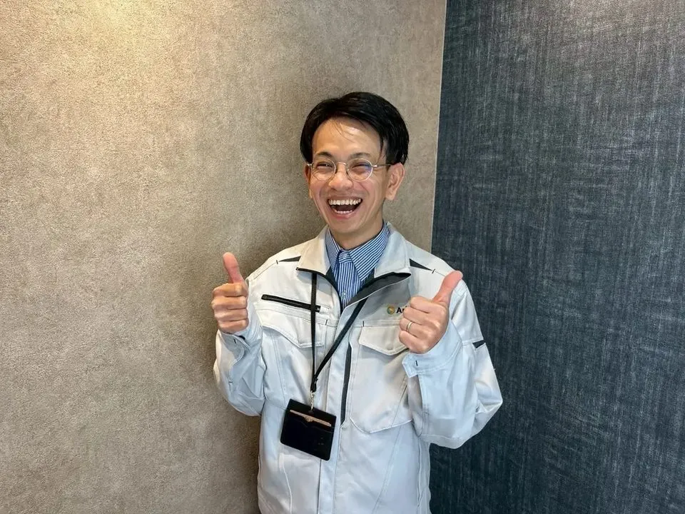 笑顔で両手の親指を立てるスタッフ