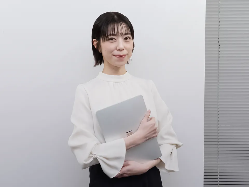 PCを手に立つ女性社員