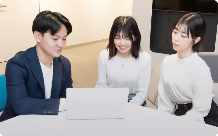 ノートPCの前で仕事をしている社員たち