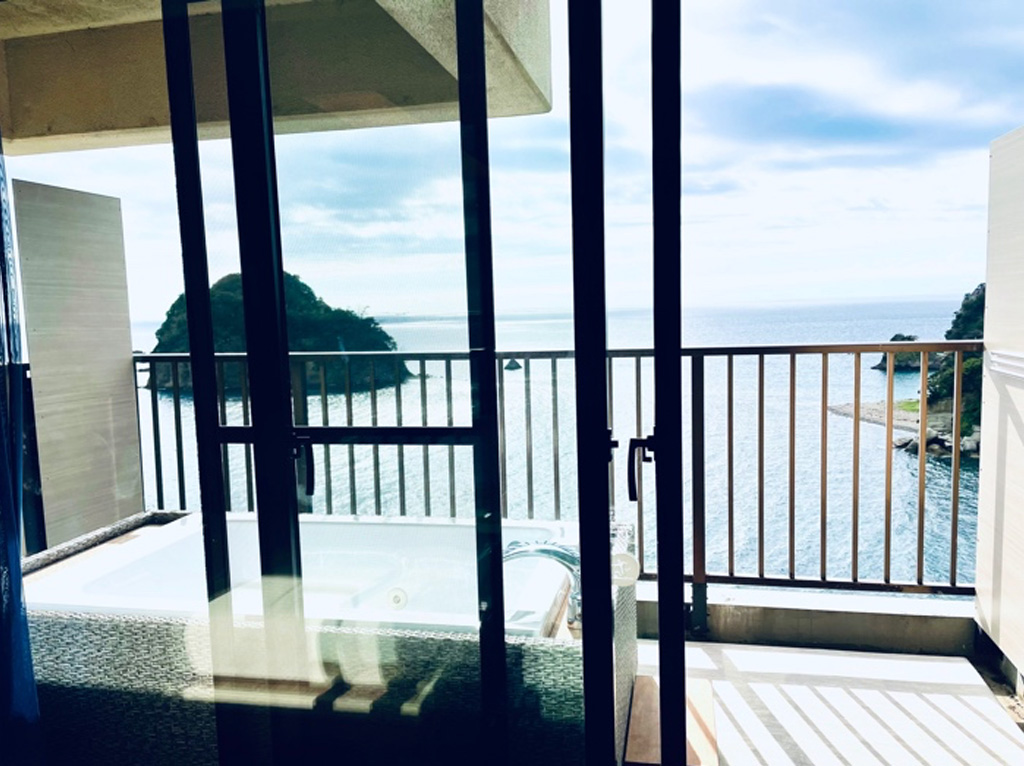 プライベート露天風呂があるバルコニーから青い海と小島を眺めることができます