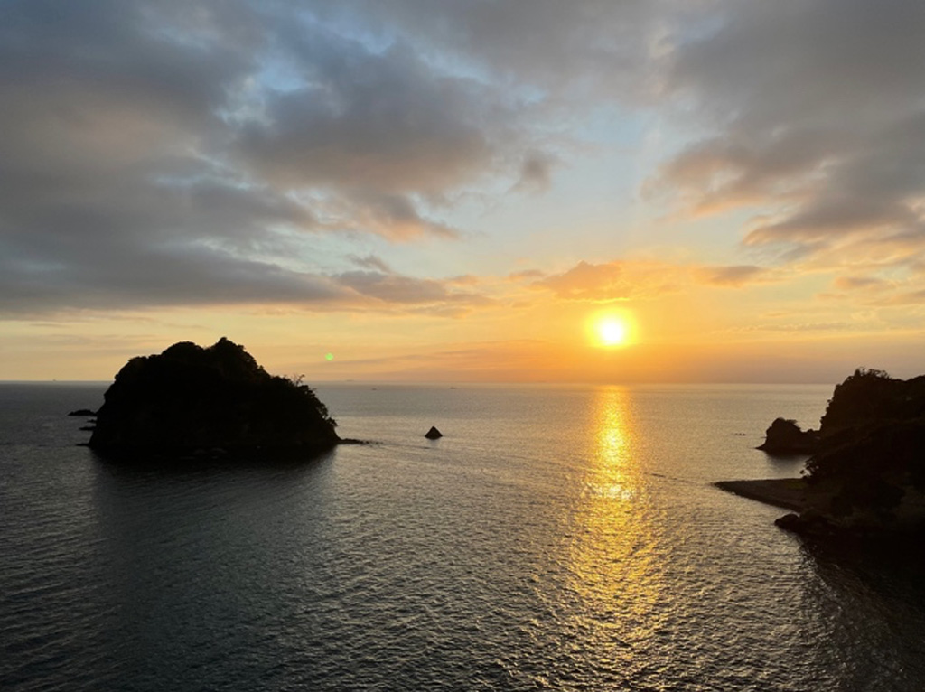 夕暮れの海景色、水平線に沈む夕日と島々のシルエット